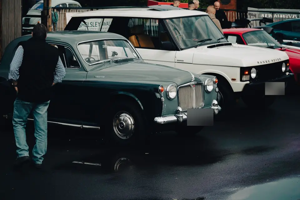 Grey and black Rover P4 saloon parked next to a white first-generation Range Rover at a car show